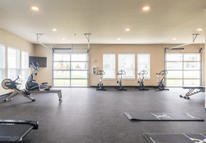 Airway Heights apartment for rent - a gym with treadmills and weights on the floor and windows