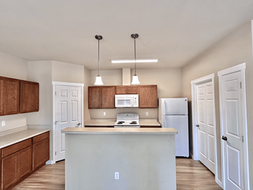 Spokane apartment for rent - A kitchen with white cabinets and a white fridge.