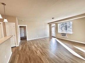 Spokane apartment for rent - A room with wooden flooring and a window showing a tree outside.