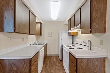 Spokane apartment for rent - A kitchen with a white stove and wooden cabinets.