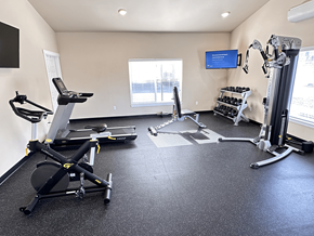 Spokane apartment for rent - A home gym with a treadmill, rowing machine, and exercise bike.