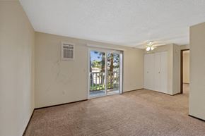Spokane apartment for rent - A room with a carpeted floor and a sliding glass door leading to a balcony.