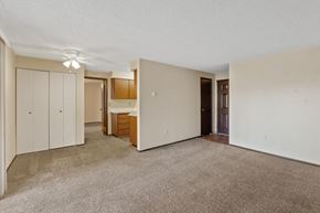 Spokane apartment for rent - A room with a carpeted floor and a brown door.