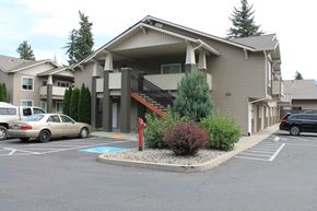 Cda apartment for rent - a building with a parking lot and cars in front of it