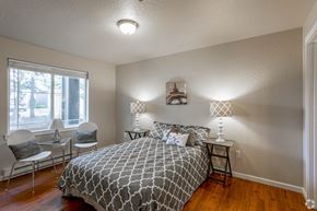 Cda apartment for rent - a bedroom with a bed and two lamps and a window