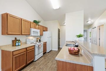 Spokane apartment for rent - A kitchen with wooden cabinets and white appliances.
