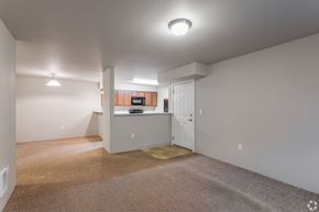 Spokane Valley apartment for rent - A spacious room with a carpeted floor and a white door.