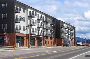 Post Falls apartment for rent - A modern apartment building with balconies and a parking lot in front.