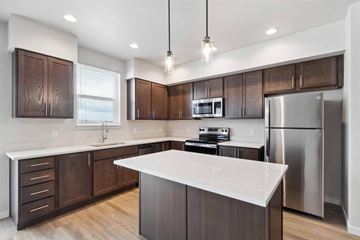 Post Falls apartment for rent - A modern kitchen with dark wood cabinets and stainless steel appliances.