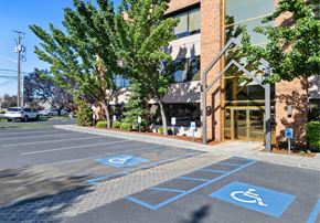 Spokane apartment for rent - A parking lot with a few cars and a building in the background.