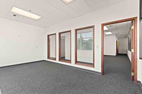 Spokane apartment for rent - A room with a grey carpet and three windows.