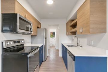 Coeur D'alene apartment for rent - A kitchen with a black oven and blue cabinets.