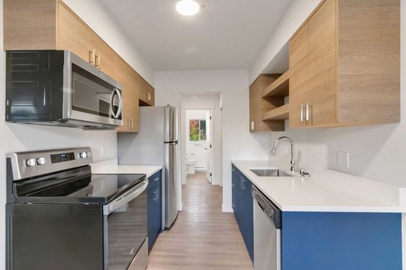 Coeur D'alene apartment for rent - A kitchen with a black oven and blue cabinets.