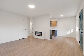 Coeur D'alene apartment for rent - A spacious room with a fireplace and wooden flooring.