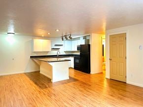 Spokane apartment for rent - A kitchen with a black fridge and white cabinets.