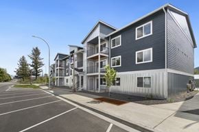 Post Falls apartment for rent - A modern apartment complex with a parking lot in front.