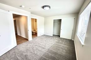 Post Falls apartment for rent - A spacious room with a carpeted floor and white walls.