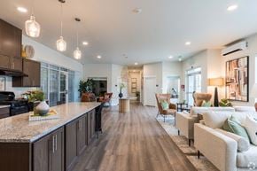 Spokane apartment for rent - A modern kitchen with a long island and a living room with a couch.