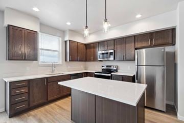 Post Falls apartment for rent - A modern kitchen with dark wood cabinets and stainless steel appliances.