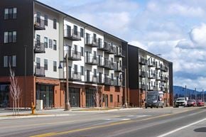 Post Falls apartment for rent - A modern apartment building with balconies and a parking lot in front.