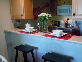 Spokane Valley apartment for rent - A kitchen with a table set for two with a vase of flowers on it.
