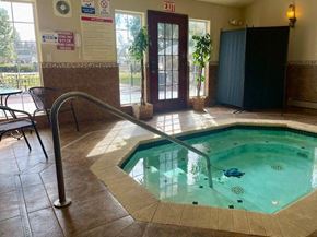 Spokane Valley apartment for rent - A pool with a metal ladder and a sign that says "EXIT" on the wall.