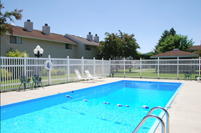 Spokane apartment for rent - a swimming pool with a fence and a house in the background