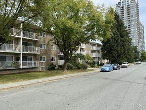 Burnaby apartment for rent - a street view of an apartment complex with cars parked on the side of the road