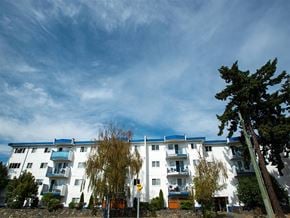Esquimalt apartment for rent - a white apartment building with a blue sky in the background