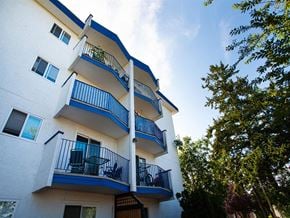 Esquimalt apartment for rent - an image of a white apartment building with blue trim