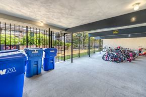 Burnaby apartment for rent - A parking garage with blue recycling bins and a yellow caution sign.