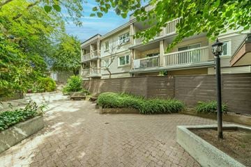 Vancouver apartment for rent - A brick walkway leads to a building with a balcony.