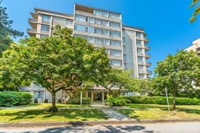 Vancouver apartment for rent - A large apartment building with a tree in front.