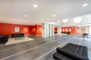 Port Coquitlam apartment for rent - A spacious waiting area with black leather seating and orange walls.