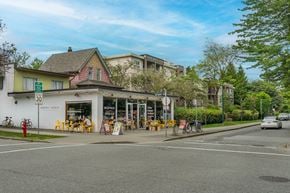 Vancouver apartment for rent - A street view with a building on the left and a car on the road.