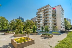 Vancouver apartment for rent - A modern apartment building with a courtyard garden in the foreground.