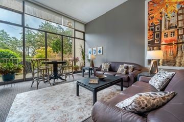 Victoria apartment for rent - A living room with a brown leather couch and a coffee table.