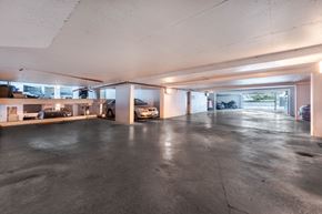 Victoria apartment for rent - A spacious garage with a concrete floor and a white ceiling.
