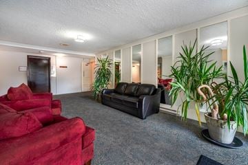 Victoria apartment for rent - A living room with a red couch and a black couch.