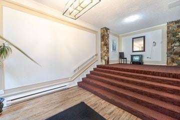 Victoria apartment for rent - A living room with a staircase leading to the second floor.