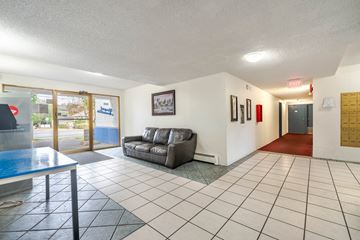 Esquimalt apartment for rent - A living room with a grey couch and a glass table.