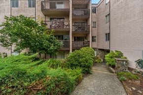 Victoria apartment for rent - A concrete pathway leads to a building with a balcony.
