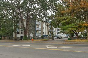 Esquimalt apartment for rent - A street with a crosswalk and a sign on the sidewalk.