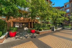 North Vancouver apartment for rent - A courtyard with a building in the background and red planters in the foreground.
