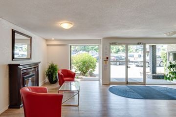 Esquimalt apartment for rent - A living room with a fireplace and a red chair.