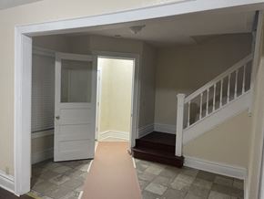 Milwaukee apartment for rent - A hallway with a white door and a staircase.