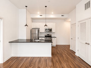 Philadelphia apartment for rent - A kitchen with white cabinets and a black countertop.