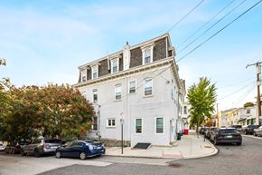Philadelphia apartment for rent - a white building with cars parked in front of it on a city street