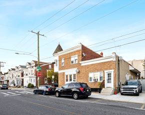 Philadelphia apartment for rent - Cars parked on the side of a street in front of a brick building.