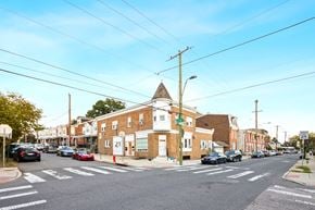 Philadelphia apartment for rent - A street view with cars, buildings, and a pedestrian crossing.
